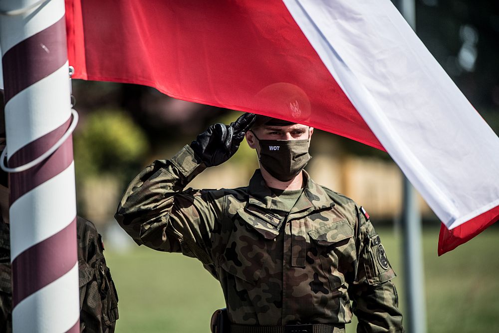 Zdjęcie żołnierza i flagi Polski. 
